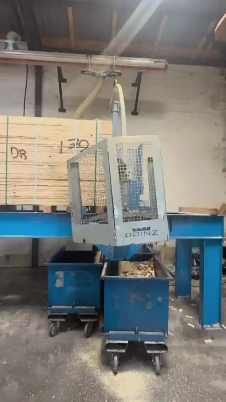Industriesäge in der Palettenproduktion, daneben ein Stapel Schnittholz